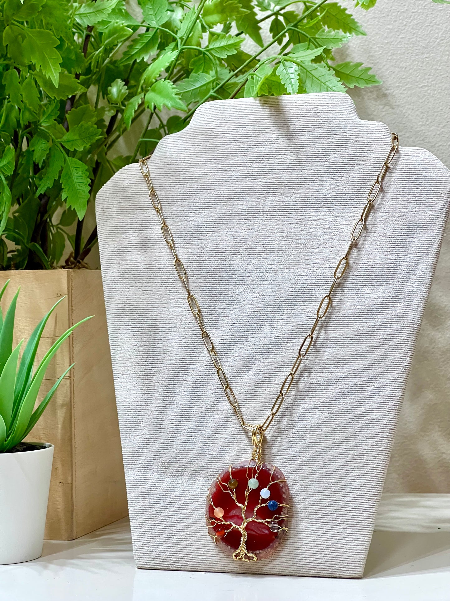 Collar acero y piedra natural sobre árbol