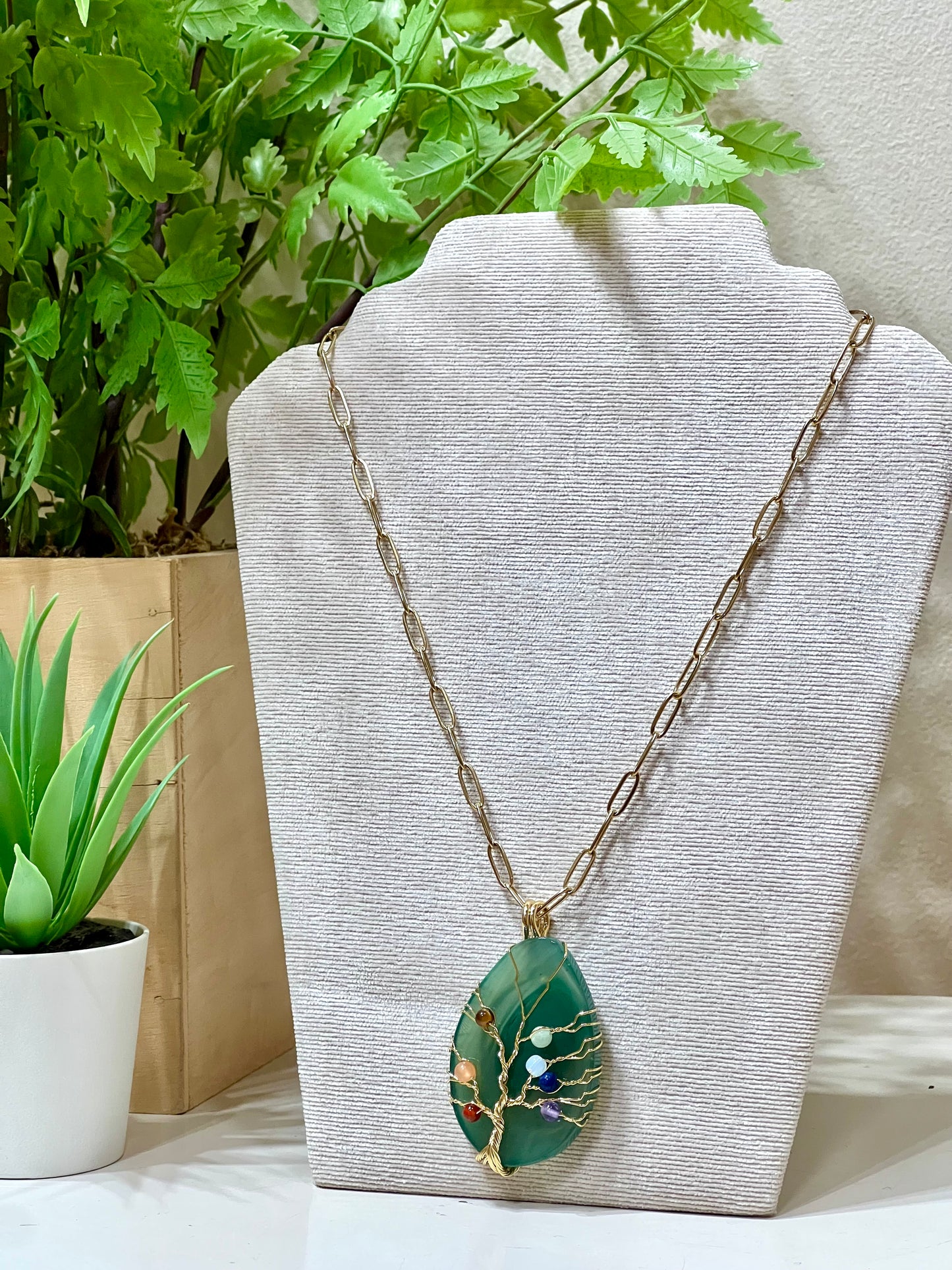 Collar acero y piedra natural sobre árbol