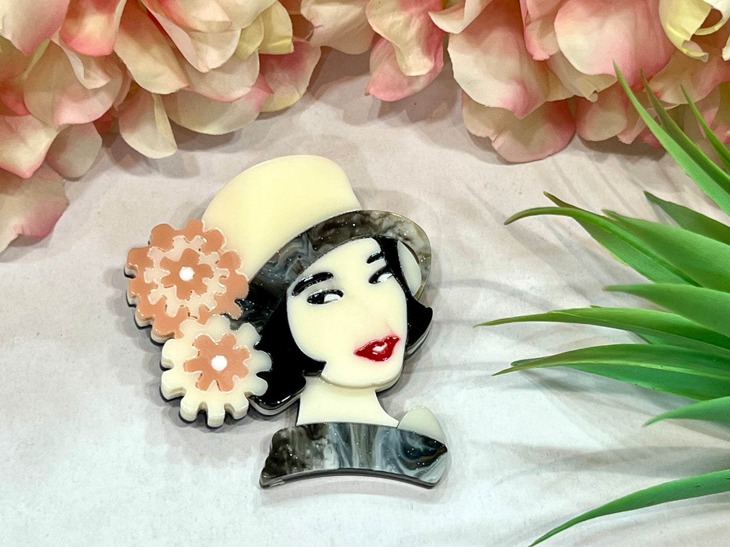 Broche con muñeca y sombrero