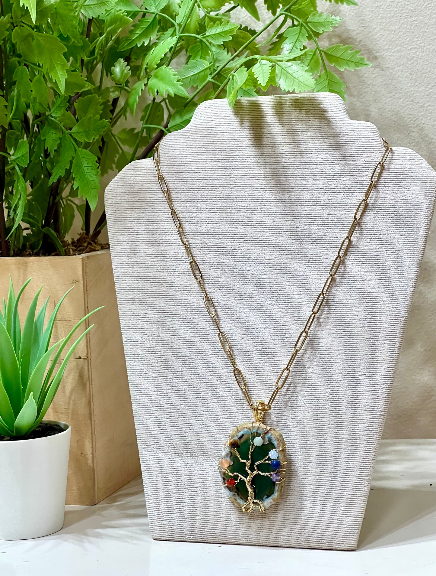 Collar acero y piedra natural sobre árbol