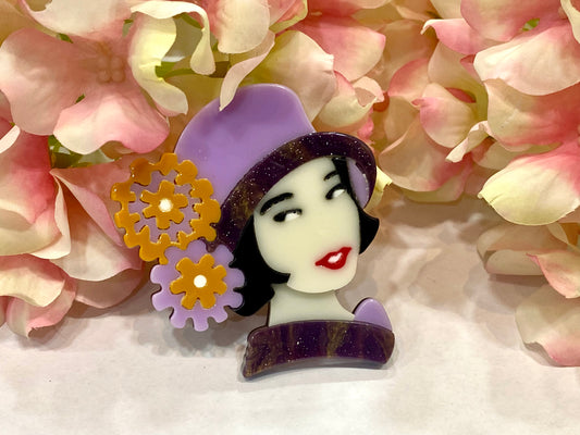 Broche con muñeca y sombrero